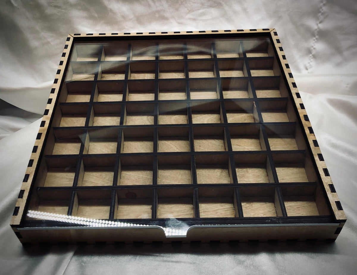 A 13" x 13" laser-cut typeset drawer with a grid of cubby spaces, featuring a clear acrylic lid. The internal dividers do not reach the full height of the drawer, allowing for ample clearance for standard typesets.