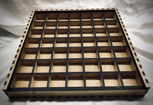 A 13" x 13" laser-cut typeset drawer with a grid of cubby spaces. The internal dividers  do not reach the full height of the drawer, allowing for ample clearance for standard typesets.