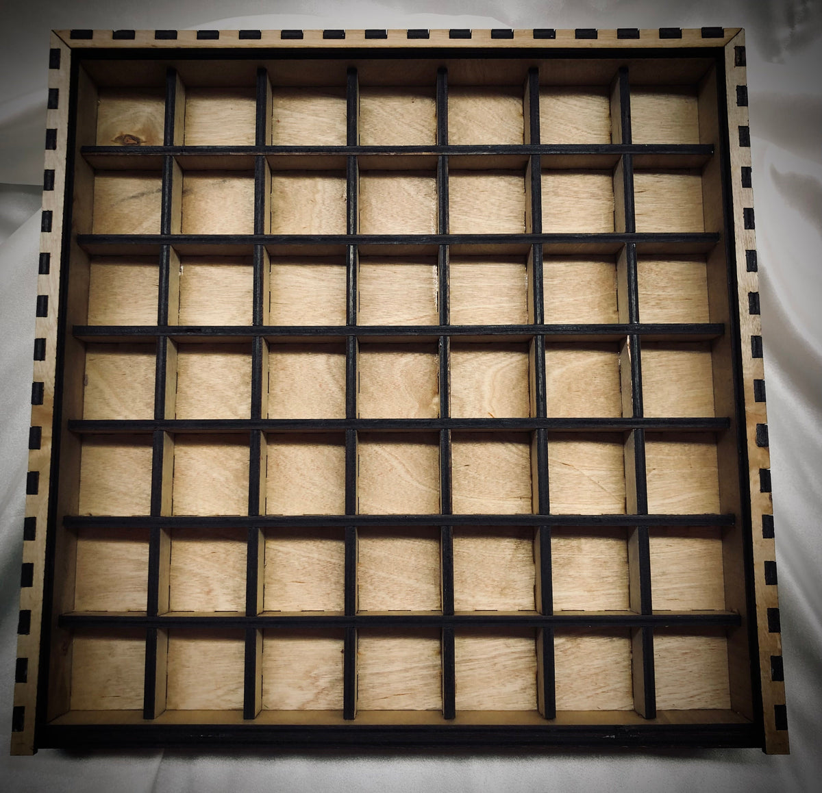 Top view of the 13" x 13" laser-cut typeset drawer with a grid of cubby spaces. The internal dividers  do not reach the full height of the drawer, allowing for ample clearance for standard typesets.